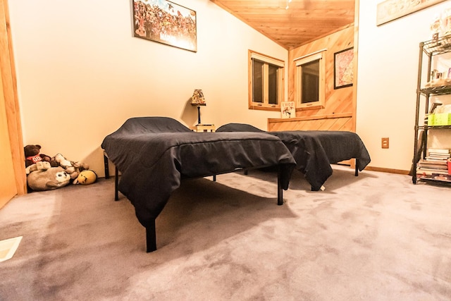 carpeted bedroom featuring wood walls, wooden ceiling, and vaulted ceiling