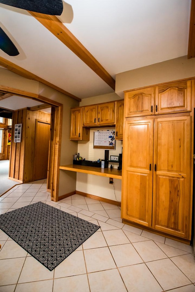 kitchen with beamed ceiling and light tile patterned floors