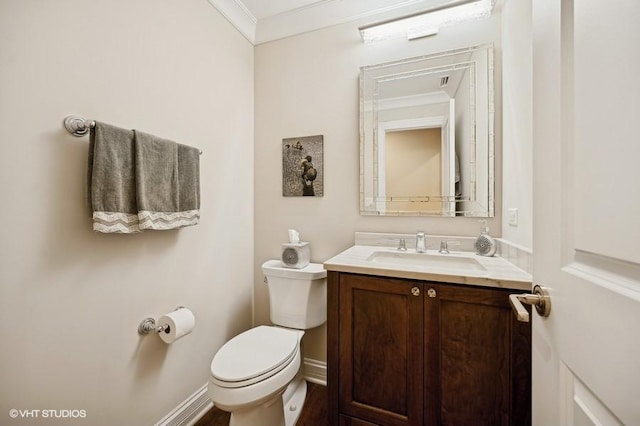 bathroom with vanity, toilet, and ornamental molding