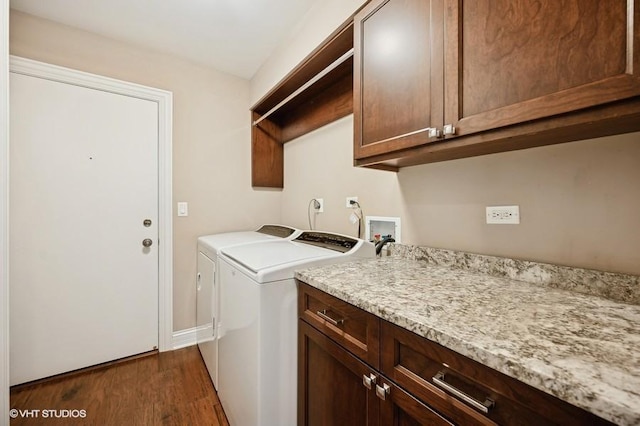 laundry area with washer and clothes dryer, dark hardwood / wood-style floors, and cabinets