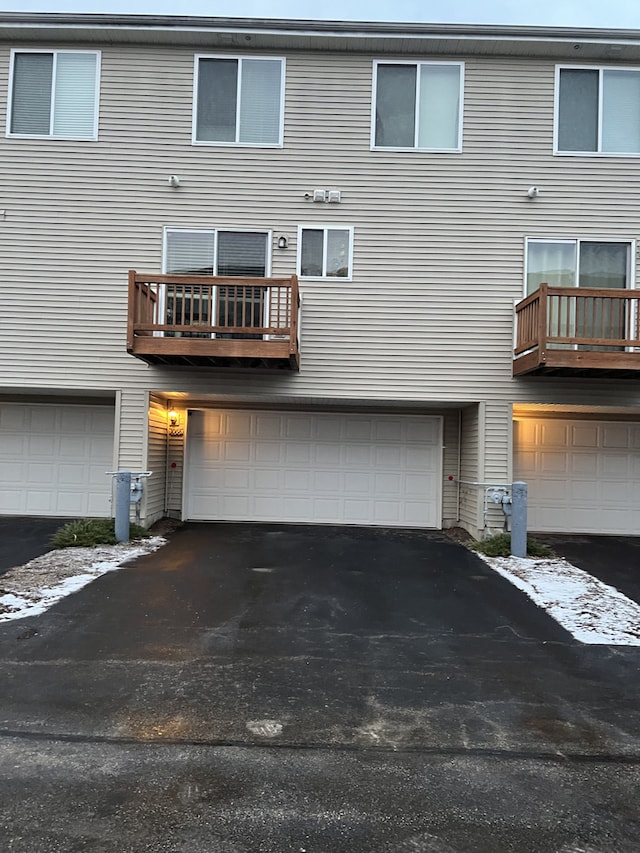 back of property featuring a balcony and a garage