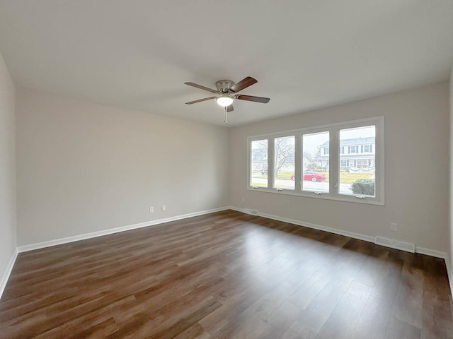 unfurnished room with ceiling fan and dark wood-type flooring