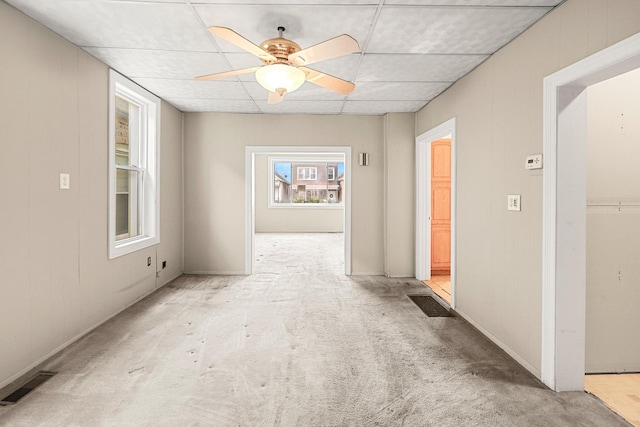 hall featuring light colored carpet and a drop ceiling