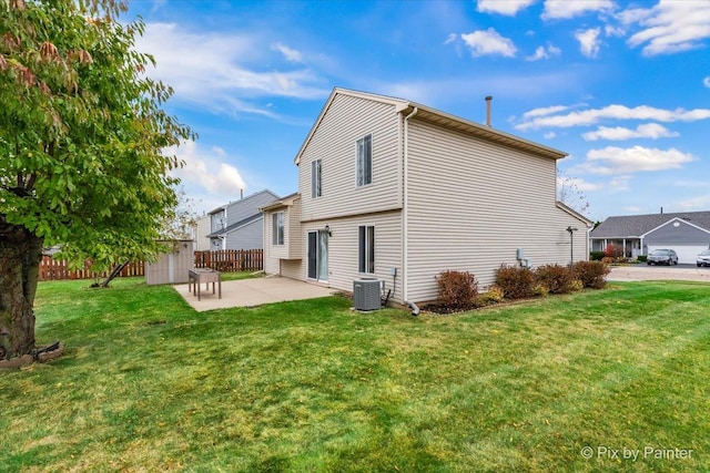 back of property featuring a lawn, a storage unit, cooling unit, and a patio