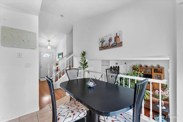 dining space with light hardwood / wood-style flooring and lofted ceiling