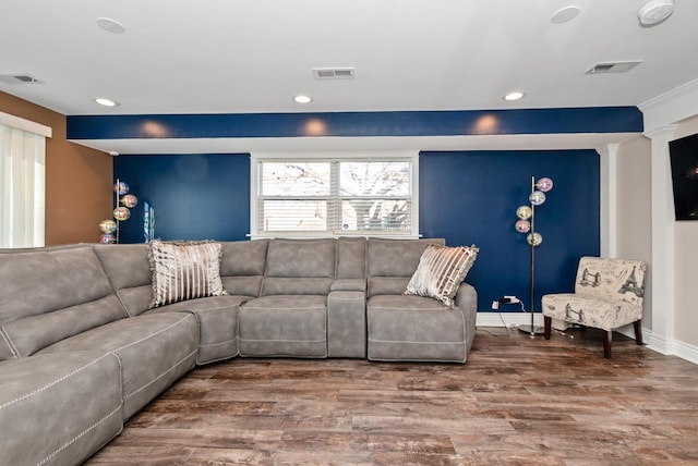 living room featuring decorative columns, wood finished floors, and visible vents