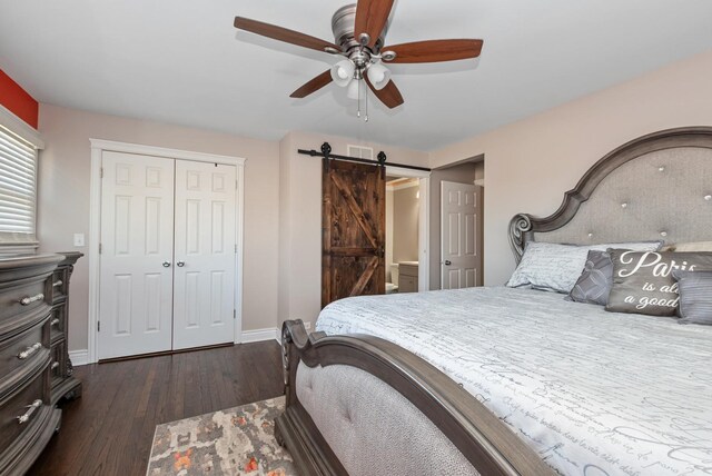 bedroom featuring baseboards, visible vents, dark wood finished floors, a closet, and a barn door