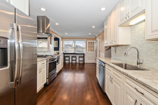 kitchen with a sink, light stone countertops, stainless steel appliances, wall chimney exhaust hood, and dark wood-style flooring