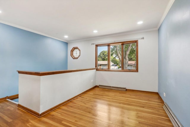 empty room featuring a baseboard heating unit, light wood-type flooring, and ornamental molding