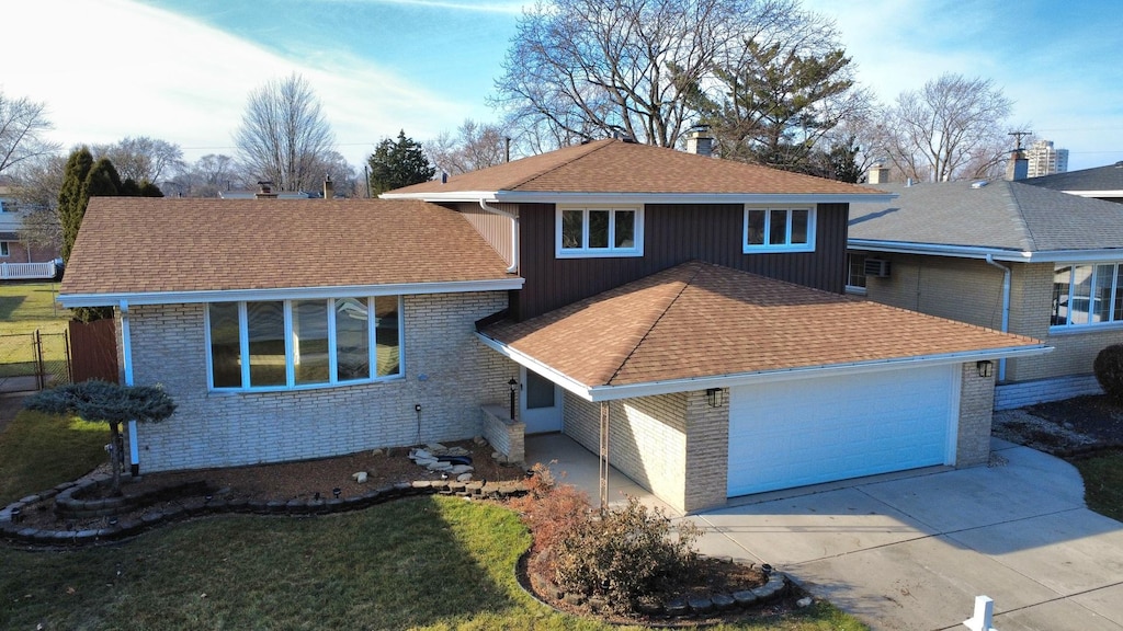 tri-level home with a garage and a front lawn