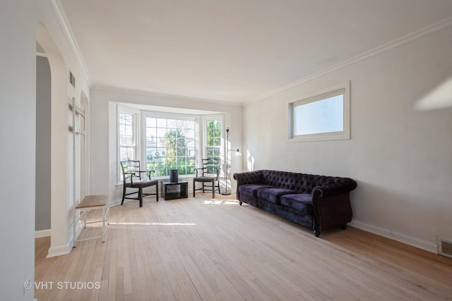 living room featuring crown molding and light hardwood / wood-style floors