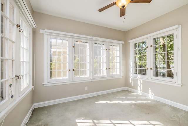 unfurnished sunroom featuring ceiling fan