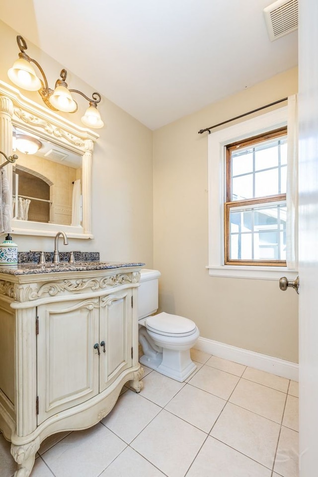 bathroom with tile patterned flooring, vanity, and toilet