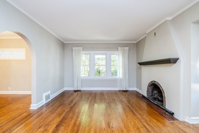 unfurnished living room with hardwood / wood-style flooring and crown molding