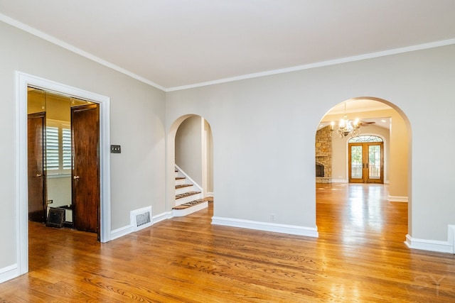 unfurnished room with french doors, ornamental molding, a notable chandelier, and hardwood / wood-style flooring