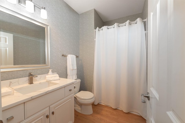 bathroom with hardwood / wood-style flooring, toilet, vanity, and a shower with curtain