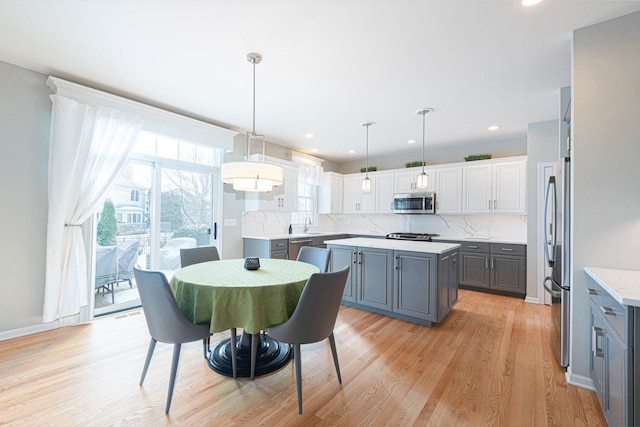 dining area with light wood-type flooring and sink