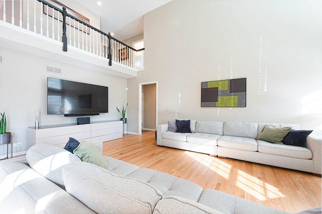 living room with hardwood / wood-style flooring and a high ceiling