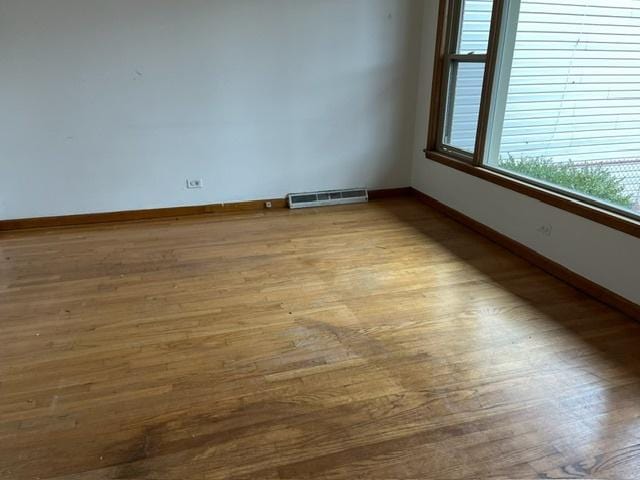 unfurnished room with hardwood / wood-style flooring