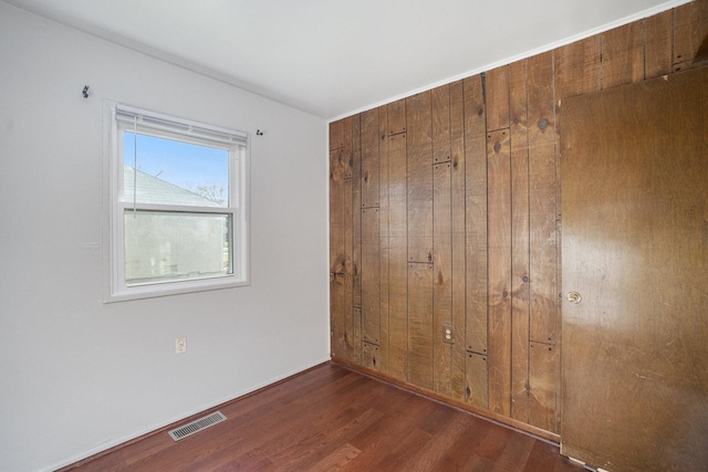 unfurnished bedroom with dark wood-type flooring and a closet