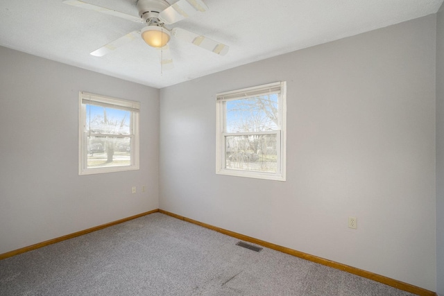 carpeted spare room featuring ceiling fan