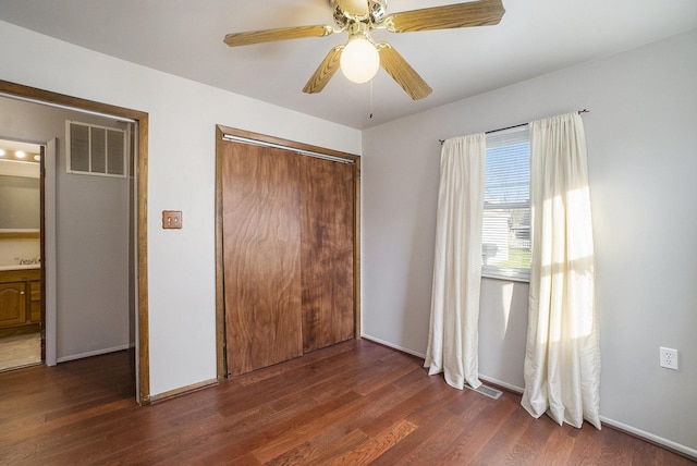 unfurnished bedroom with a closet, ceiling fan, and dark wood-type flooring