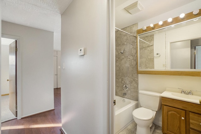 full bathroom with toilet, hardwood / wood-style floors, vanity, and tiled shower / bath combo