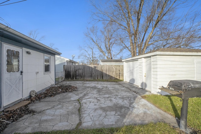 exterior space featuring a garage, an outbuilding, and a patio