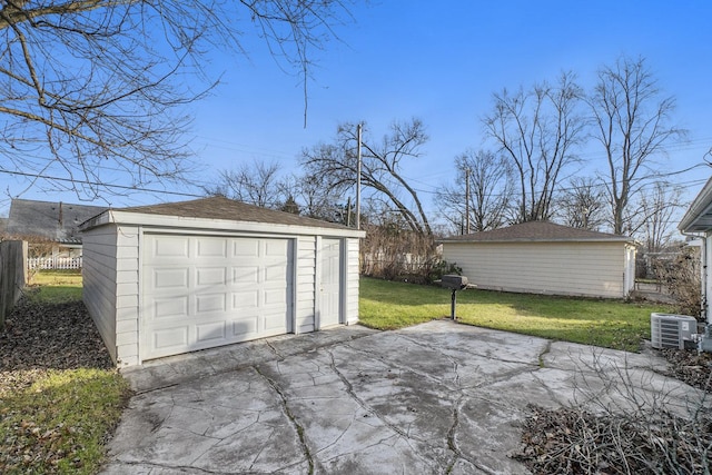 garage with central AC unit and a lawn