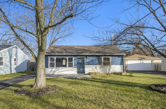 ranch-style home featuring an outbuilding, a garage, and a front lawn