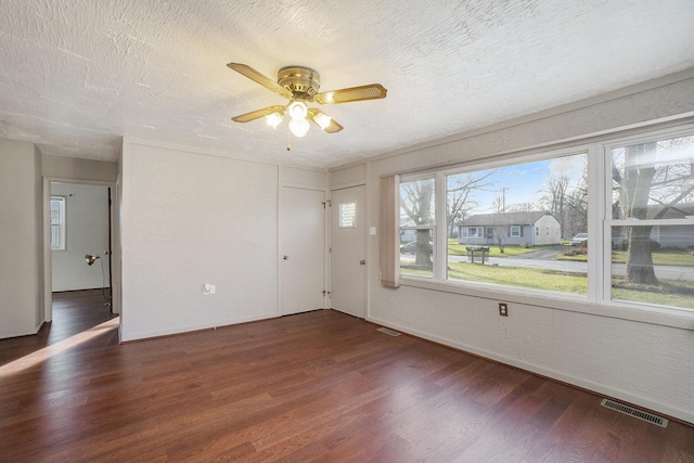 unfurnished room featuring ceiling fan, dark hardwood / wood-style flooring, and a textured ceiling