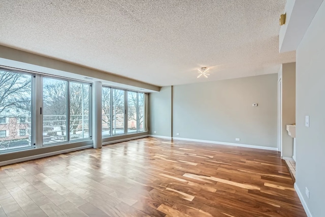 unfurnished room featuring a textured ceiling and light hardwood / wood-style floors