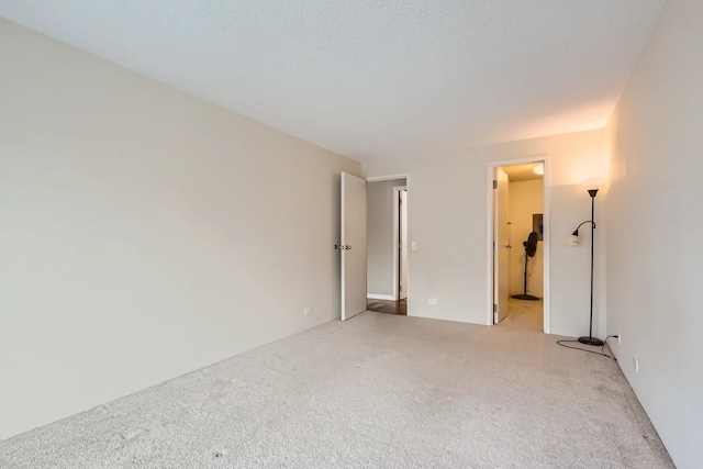 carpeted empty room featuring a textured ceiling