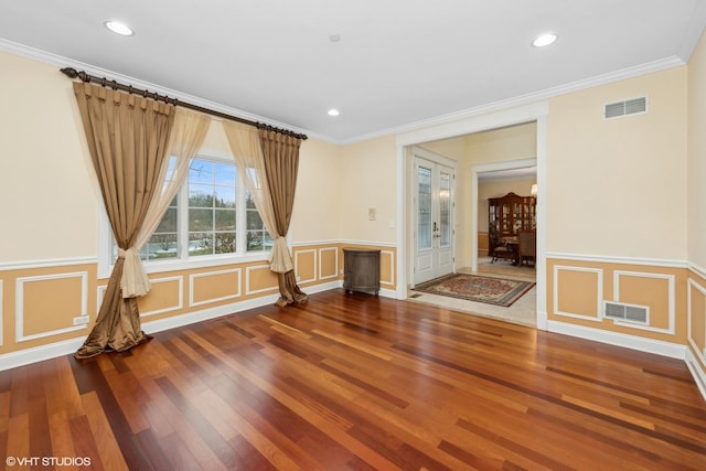 spare room featuring crown molding and wood-type flooring