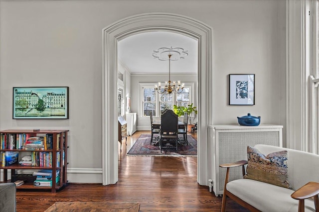 hallway featuring crown molding, an inviting chandelier, and dark hardwood / wood-style flooring