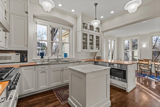 kitchen featuring white cabinetry, pendant lighting, stainless steel appliances, and a kitchen island