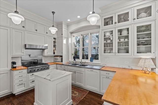 kitchen with ventilation hood, white cabinetry, sink, and pendant lighting