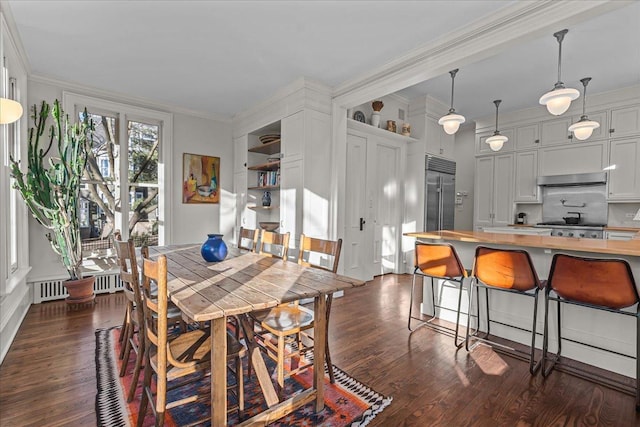 dining space featuring dark wood-type flooring, ornamental molding, and radiator heating unit