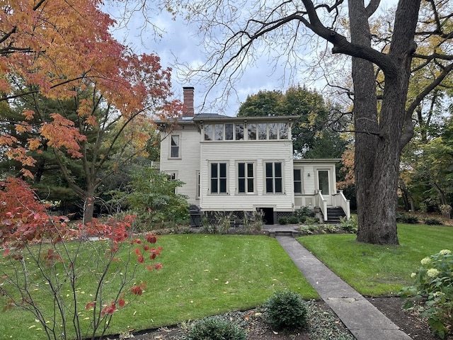 view of front facade with a sunroom and a front yard