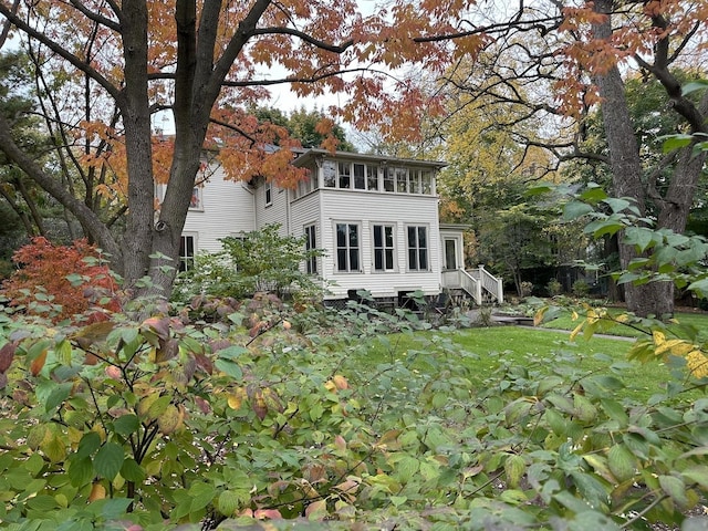 rear view of property with a yard and a sunroom