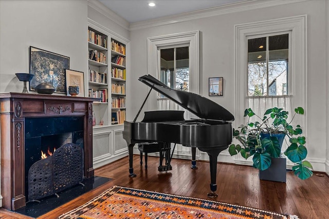 miscellaneous room with crown molding, built in features, and hardwood / wood-style flooring