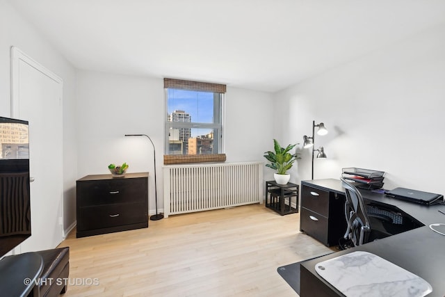 home office with radiator and light hardwood / wood-style flooring