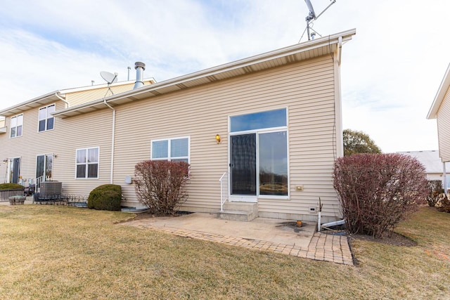 back of property featuring a lawn, cooling unit, and a patio