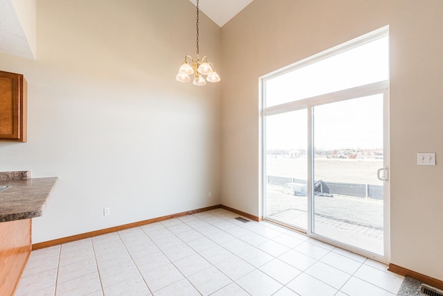 unfurnished dining area featuring light tile patterned flooring, vaulted ceiling, and an inviting chandelier