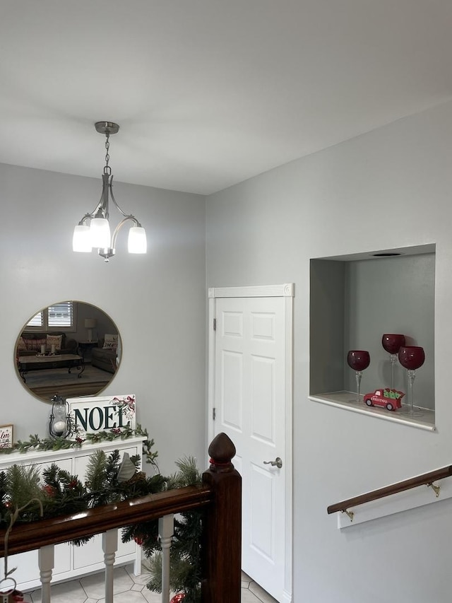 hallway featuring a notable chandelier and light tile patterned floors