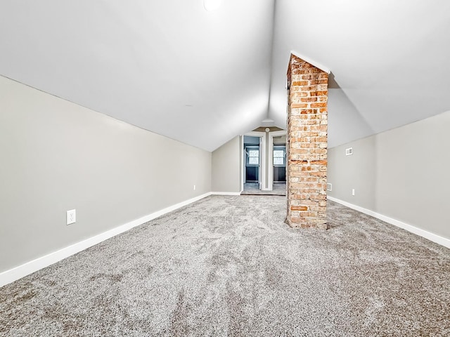 additional living space featuring carpet flooring and vaulted ceiling