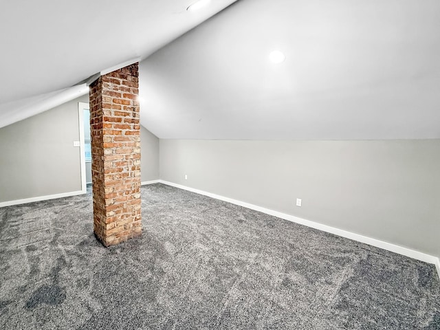 bonus room featuring dark colored carpet and lofted ceiling