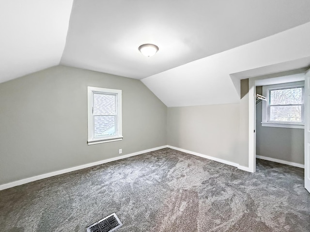 bonus room featuring dark carpet and lofted ceiling