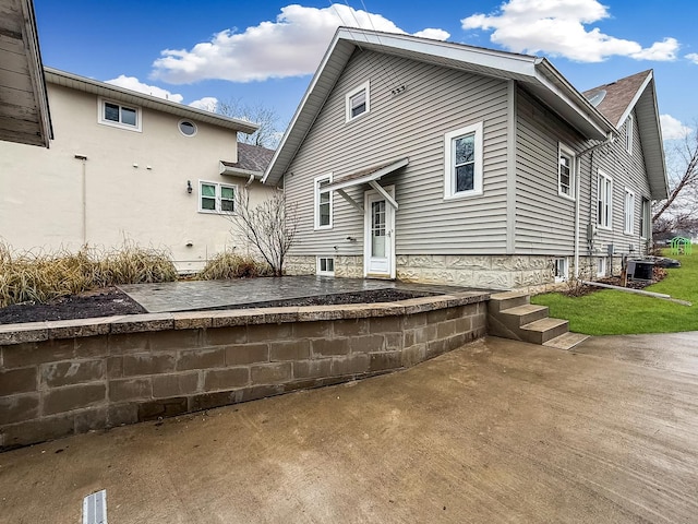 rear view of property featuring central air condition unit and a patio area