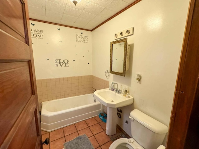 bathroom featuring tile patterned flooring, a washtub, toilet, and crown molding